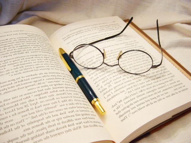 眼镜和笔放在打开的书上
