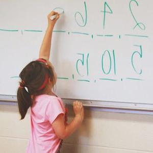 一个孩子在白板上写数字