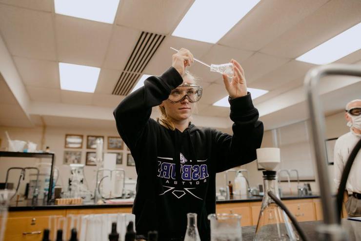 一名立博体育登录的本科生在科学实验室里使用烧杯
