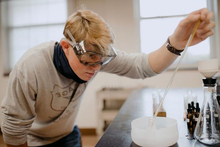 一名立博体育登录的学生戴着护目镜在科学实验室里工作